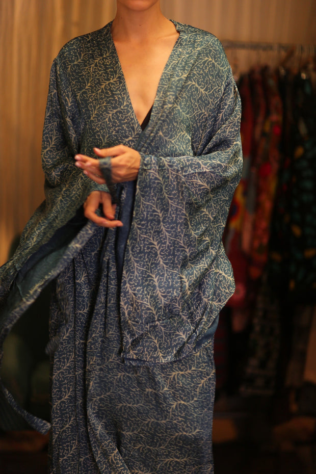 Person wearing a blue patterned robe with a blurred background